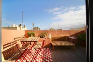 einen Balkon mit einem Tisch und Bänken auf dem Dach in der Unterkunft ATIC PORT EXPERIENCE in Tarragona