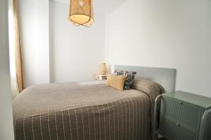 ein Schlafzimmer mit einem Bett mit einem Kissen darauf in der Unterkunft ATIC PORT EXPERIENCE in Tarragona
