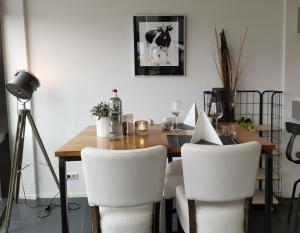 jadalnia ze stołem i białymi krzesłami w obiekcie Resort Land & Zee w mieście Scharendijke