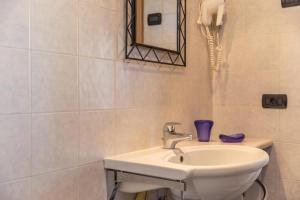 ein weißes Badezimmer mit Waschbecken und Telefon in der Unterkunft Sole - Casa Azzurra Piano Terra in Livigno + 10 Fotos