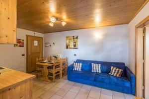 ein Wohnzimmer mit einem blauen Sofa und einem Tisch in der Unterkunft Sole - Casa Azzurra Piano Terra in Livigno