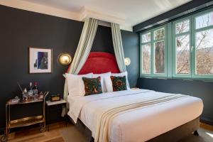 a bedroom with a large bed with a red headboard at Communal Hotel Plekhanovi in Tbilisi City