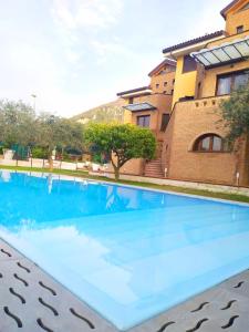 una grande piscina blu di fronte a un edificio di Villa C Luxury Estate a SantʼAntonio Abate