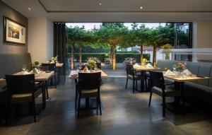 un restaurante con mesas y sillas y una gran ventana en Hotel zur Post Riesenbeck en Riesenbeck