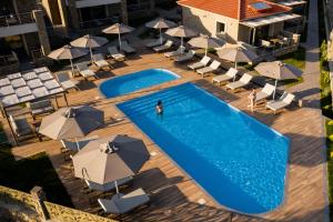 an overhead view of a swimming pool with umbrellas at Costa D' Ifesto in Agios Ioannis Kaspaka