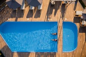 two people swimming in a swimming pool at Costa D' Ifesto in Agios Ioannis Kaspaka