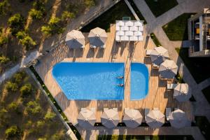 an overhead view of a swimming pool with umbrellas at Costa D' Ifesto in Agios Ioannis Kaspaka