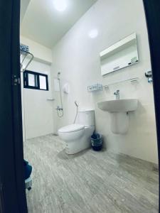 a white bathroom with a toilet and a sink at 舞艾湖民宿 in Hsing-wen