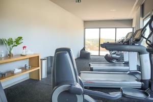 a gym with cardio equipment in a room with a window at Le Balamina in Porto-Vecchio