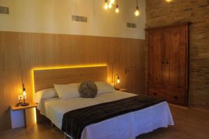 a bedroom with a large bed with a wooden headboard at A Casa da Botica in Samos