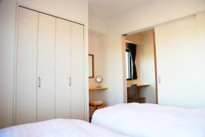 Uma cama ou camas num quarto em Yoshitsuki kaku - Yoshitsuki Apart Hotel