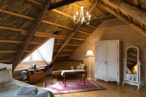 a attic room with a bed and a table and a desk at Avar puhkekompleks saunaga in Kuusiku