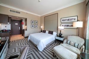 a hotel room with two beds and a television at Al Maha Arjaan by Rotana in Abu Dhabi