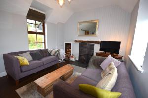 a living room with two couches and a fireplace at Arivean Cottage in Lochgoilhead