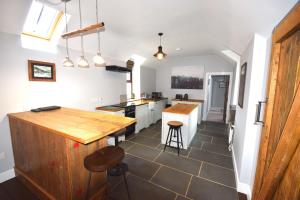 a kitchen with white cabinets and a wooden counter top at Arivean Cottage in Lochgoilhead