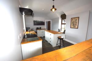 une cuisine avec des armoires blanches et un comptoir dans l'établissement Arivean Cottage, à Lochgoilhead 18 autres photos