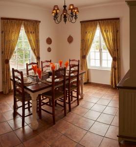 a dining room with a table and chairs and windows at De Hoop Collection - Opstal Houses in De Hoop Nature Reserve