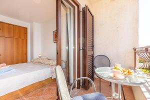 um quarto com uma cama, uma mesa e cadeiras em Apartments Banko em Rovinj