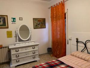 リド・ディ・オスティアにあるAppartamento Zia Gesinaのベッドルーム(鏡付きドレッサー、ベッド付)