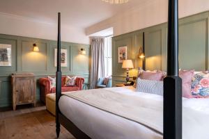 a bedroom with a large bed and a chair at The Canford in Poole