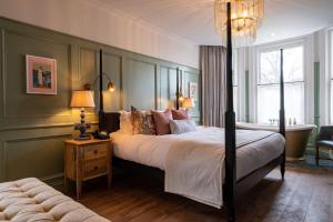 a bedroom with a large bed and a couch at The Canford in Poole