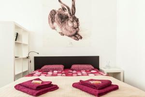 ウィーンにあるMadina Apartmentのベッドルーム1室(ピンクの枕とウサギの絵画付)