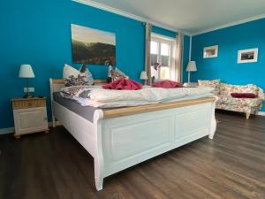 sypialnia z dużym łóżkiem z niebieskimi ścianami w obiekcie Landhaus Waltersdorf w mieście Bad Schandau