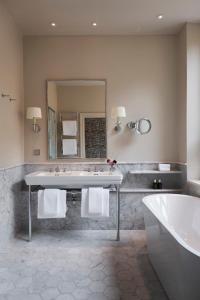 a bathroom with a sink and a tub and a mirror at Villa Dagmar in Stockholm