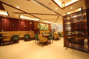 The Vilana Hotel Rishikesh في ريشيكيش: مطعم بطاولات وكراسي وبار