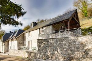 una casa de piedra con techo de pizarra en Enjoy Cottage - Holiday home with private swimming pool en Sosoye