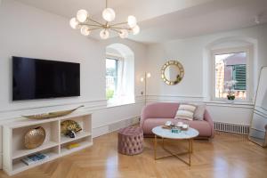 a living room with a pink couch and a tv at Deluxe Studio Rennesance Corner in Dubrovnik