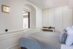 a white bedroom with a bed and a window at Deluxe Studio Rennesance Corner in Dubrovnik