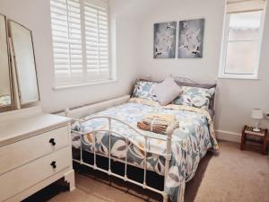 a small bedroom with a bed and a dresser at 'Little Eaton Margate' Perfectly located Town House by the Sea, with FREE parking! in Kent