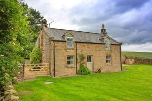 an old brick house with a green yard at Finest Retreats - Shortflatt Farm Cottage in Belsay