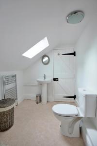 a white bathroom with a toilet and a sink at Finest Retreats - Shortflatt Farm Cottage in Belsay
