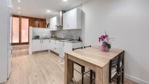 a kitchen with white cabinets and a wooden table at BEHEKO ETXEA in Lekeitio
