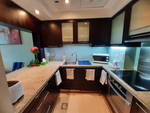 a kitchen with a sink and a counter top at Bright Sunny Dubai Apartment- Private Terrace Garden- Canal Views- Pool & Gym in Dubai