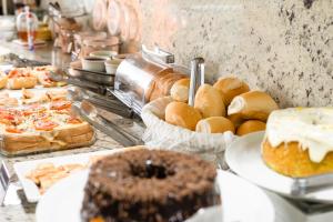 a buffet filled with different types of pastries and cakes at Caligio Hotel in Pirapòzinho