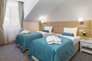 Łóżko lub łóżka w pokoju w obiekcie Palac Mortegi Hotel & SPA- Restauracja Szlachecka, SPA, Basen, Sauny, Jazda Konna, Mini Zoo- Luksus, Relaks i Przyroda w jednym!