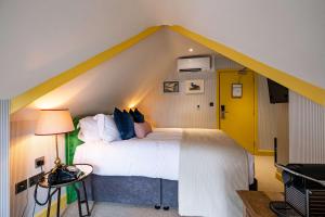 a bedroom with a large bed with a yellow roof at The Canford in Poole