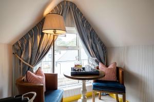a room with a table and chairs and a window at The Canford in Poole