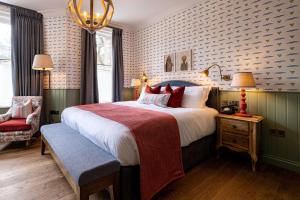 a bedroom with a large bed and a red chair at The Canford in Poole