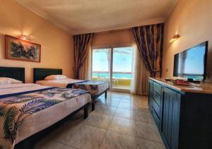 a hotel room with two beds and a flat screen tv at Palm Beach Resort Families and Couples only in Hurghada