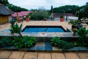a swimming pool in a patio with plants at Beautiful ocean view guest house in Tugela Mouth