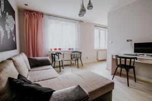uma sala de estar com um sofá e uma mesa com cadeiras em Good Place em Gdynia