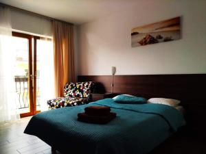 sypialnia z łóżkiem, krzesłem i oknem w obiekcie Grot w mieście Mrzeżyno