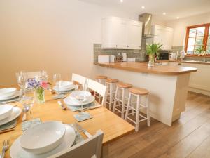 a kitchen with a wooden table with white dishes on it at Thrushel Cottage in Lifton