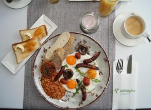 a plate of breakfast food with eggs beans and toast at Holiday Inn Łódź by IHG in Łódź +85 photos