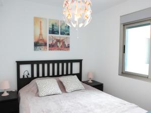 1 dormitorio con cama y lámpara de araña en Mar Azul 378 Manga Norte, en Murcia