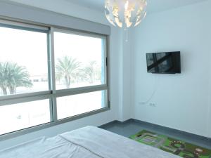 ein Schlafzimmer mit 2 Fenstern, einem Bett und einem Kronleuchter in der Unterkunft Mar Azul 378 Manga Norte in Murcia